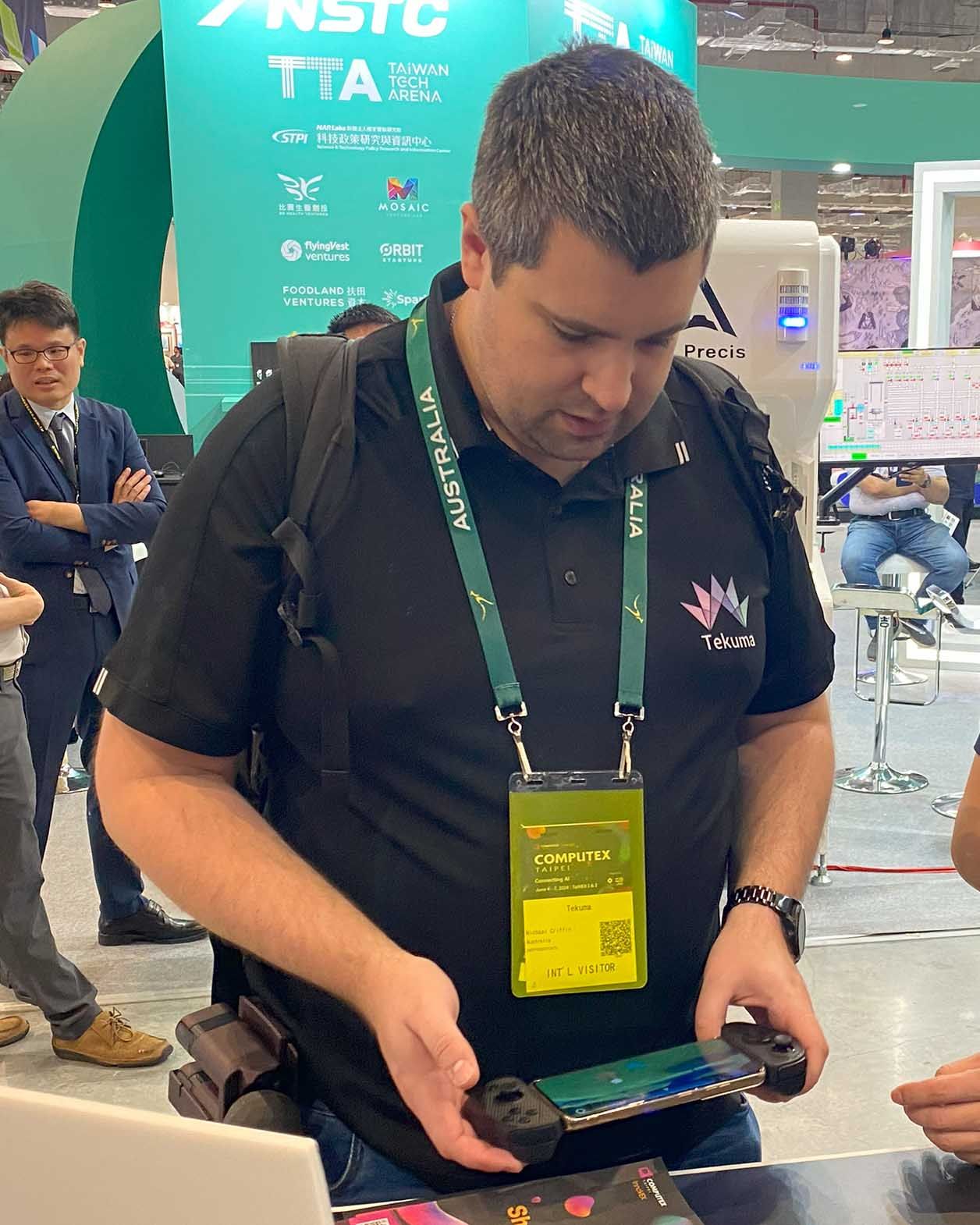 A man holds the Serafim S3 controller, saying, "This will improve my mobile gaming experience. I’m so much more precise with this controller." at Computex 2024